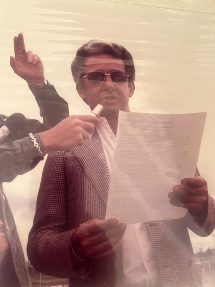 Tomaz Edison de Andrade Vieira lê um discurso ao microfone, ao ar livre